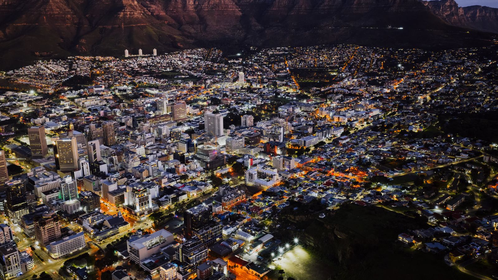A stunning aerial view of Cape Town city lights at night against Table Mountain.