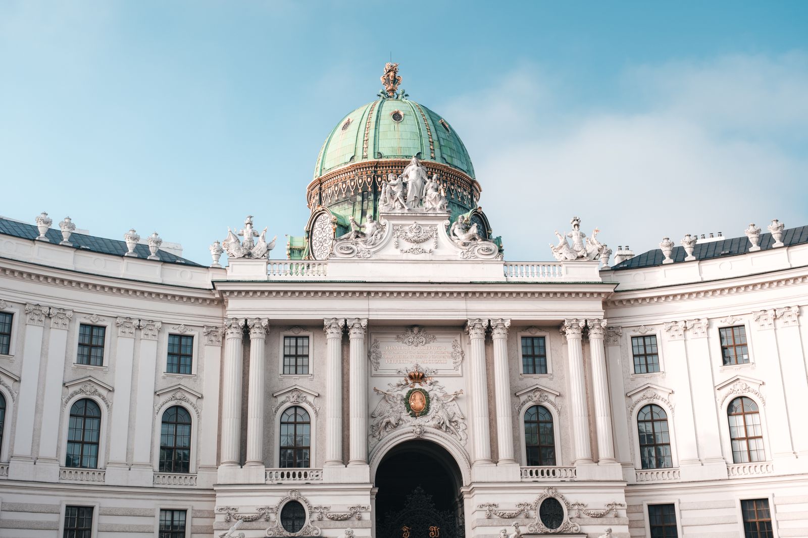 Elegant view of the Hofburg Palace's dome and facade in Vienna, Austria under a clear sky.