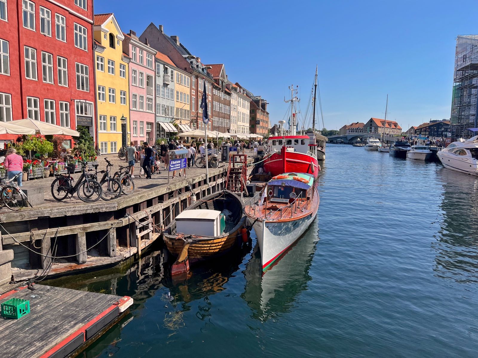 Colorful buildings and boats along Nyhavn canal in Copenhagen, Denmark, on a sunny day.