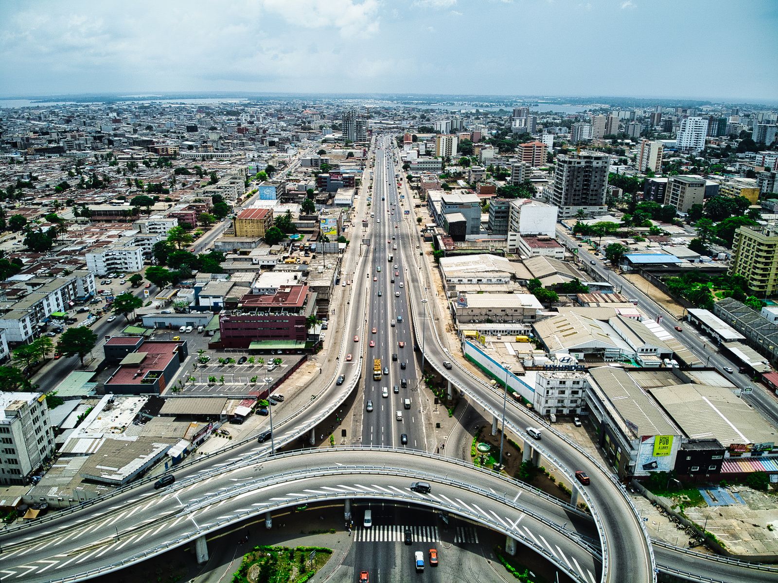A stunning aerial view of a bustling expressway in Abidjan, Côte d'Ivoire, showcasing urban architecture and transportation.